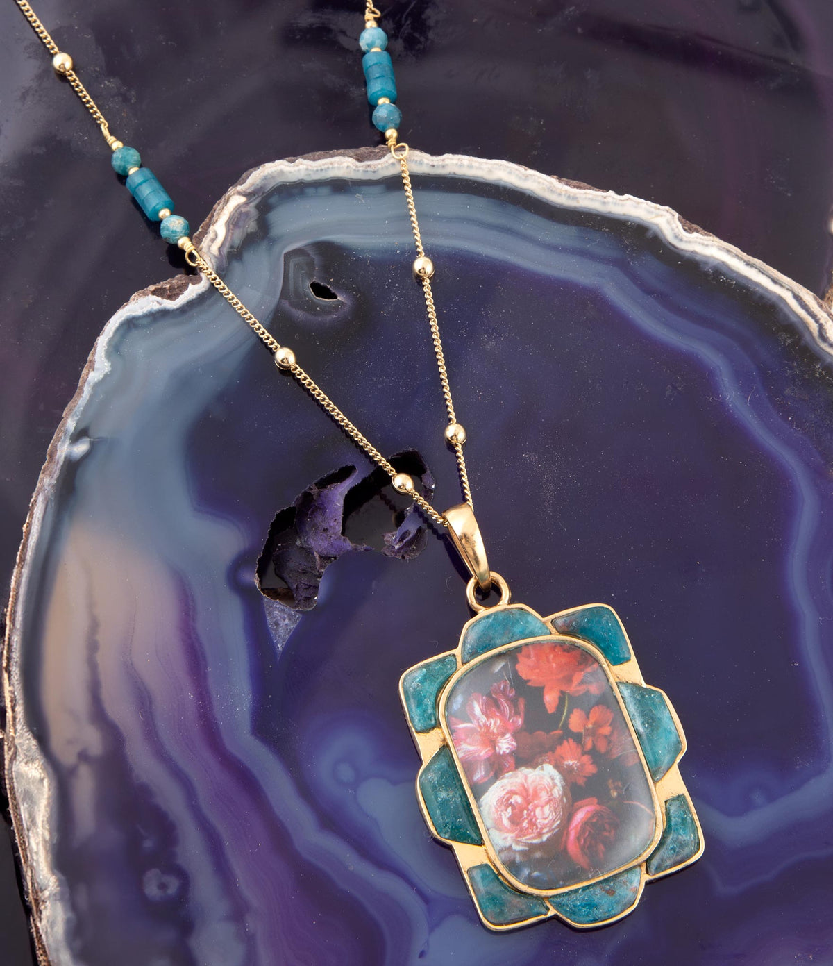 Collar con colgante dorado de apatita azul y motivos florales rojos escénicos