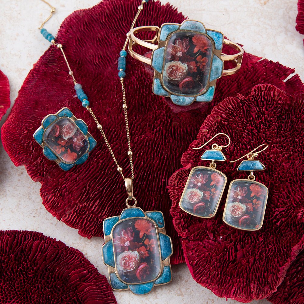 Collar con colgante dorado de apatita azul y motivos florales rojos escénicos