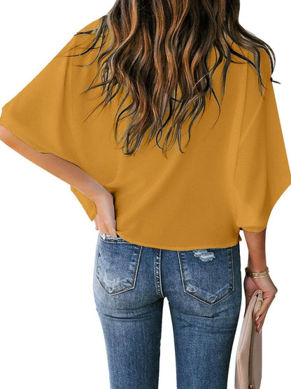 Back view of woman wearing mustard yellow three-quarter sleeve blouse for women with casual blue jeans